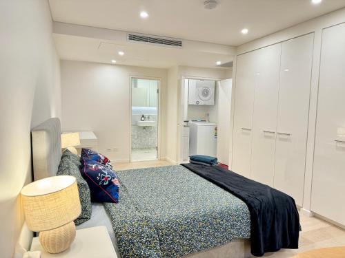 a bedroom with a bed and a couch and a refrigerator at New Town Studio in Sydney