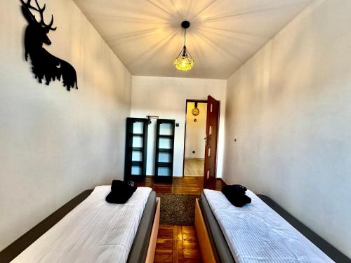 a room with two beds in a room with a deer head on the wall at Domek Monte Black z jacuzzi i sauną fińską in Stronie Śląskie