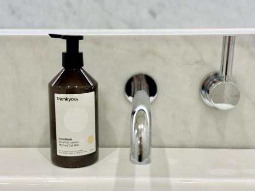 a bottle of soap sitting next to a sink at New Town Studio in Sydney