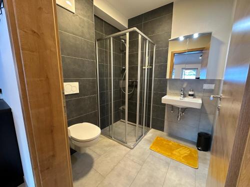 uma casa de banho com um chuveiro, um WC e um lavatório. em DARO living Top 7 em Sankt Margarethen im Lungau