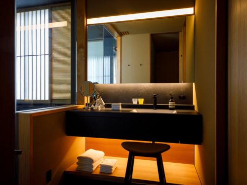 a bathroom with a sink and a mirror at 黒梅屋 Kurumiya in Kanazawa