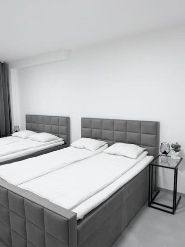 Duas camas grandes num quarto com uma mesa lateral. em NEW Modern Large Apartment in New Town 3BDR em Praga