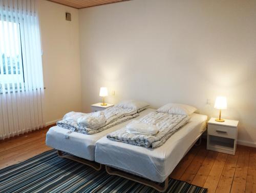 (Id022) Strandby Kirkevej 270 1 th في إيسبيرغ: سريرين توأم في غرفة بها مصباحين