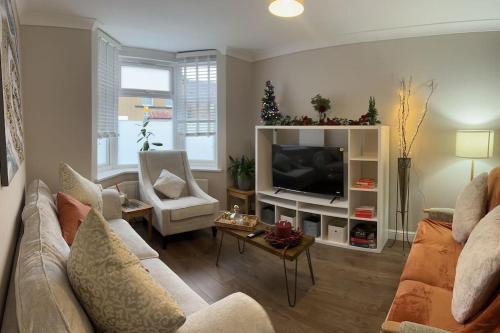 a living room with a couch and a television at Adam’s Place, Watford WD17 2PY (near Harry Potter) in Watford