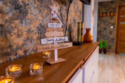 a christmas tree on top of a counter with candles at Dusznickie Apartamenty Julia in Duszniki Zdrój