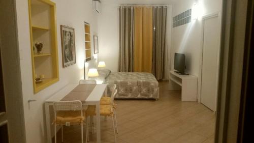 a room with a bed and a table and a television at Tortugas B&B in Giarre