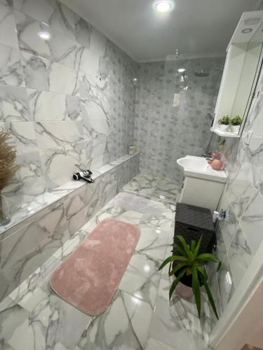bagno con pareti in marmo e lavandino di Fairytale Apartment a Sarajevo