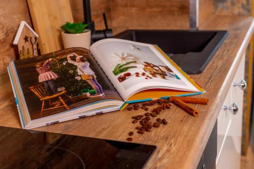 an open book sitting on a counter with coffee beans at Dusznickie Apartamenty Julia in Duszniki Zdrój