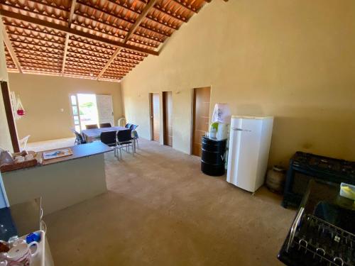 eine leere Küche und ein Wohnzimmer mit einem Kühlschrank in der Unterkunft Chácara Moreira in Tianguá