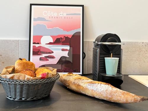 une table avec un panier de pain et un verre de lait dans l'établissement Gite Le Bolzen, à Lézardrieux