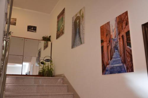 a hallway with paintings on the wall and stairs at Apartments Mistral in Mimice