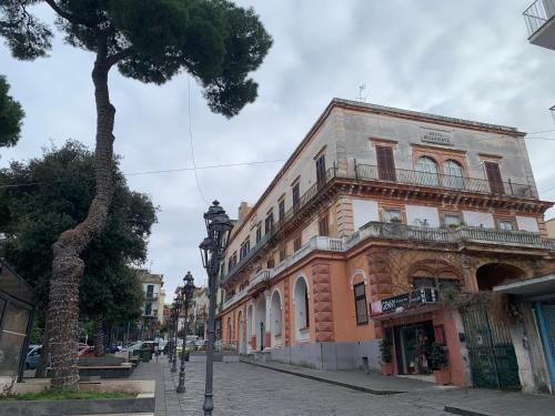 un bâtiment sur le côté d'une rue avec un arbre dans l'établissement Il Poli, à Portici