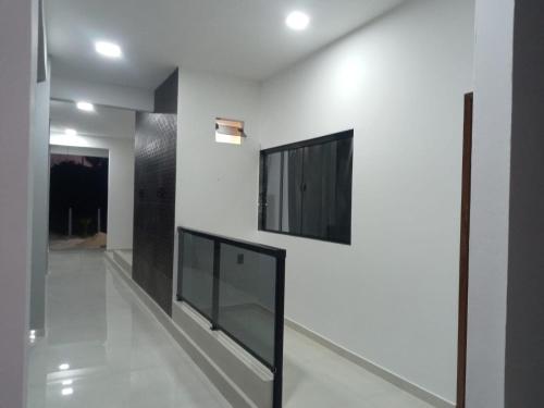 um corredor com paredes brancas e uma televisão numa parede em VR Flats em Maragogi