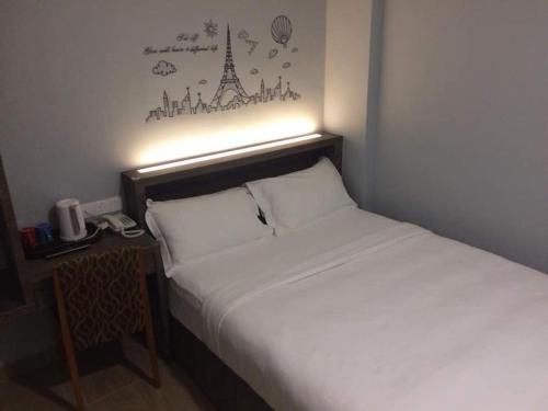 a bedroom with a bed and a desk with a telephone at Sunlight Hotel Kulai in Kulai