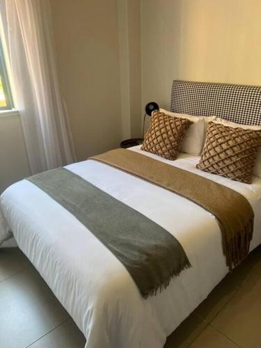 a bedroom with a large bed with pillows on it at Premium Cozy Apartment (0% loadshedding) in Sandton