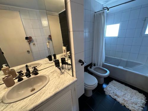 a bathroom with a sink and a toilet and a tub at Hotel Butique Donatella Mare. in Punta del Este