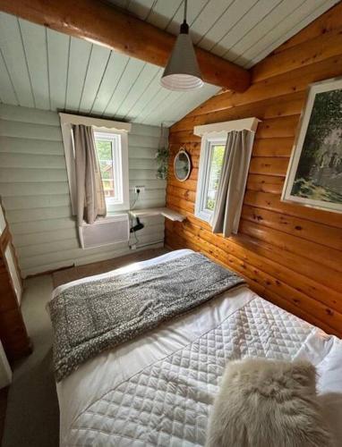 a bedroom with a large bed in a log cabin at Snug and cosy log cabin. in Trawsfynydd