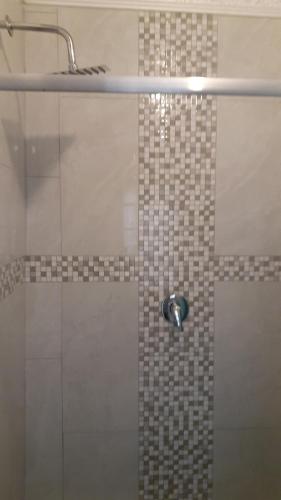 La salle de bains est pourvue d'une douche avec une porte en verre. dans l'établissement Russell's Rest Rooms, à Johannesbourg
