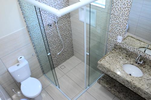 een badkamer met een douche, een toilet en een wastafel bij Villa Encantos Casa de Campo in Serra Negra