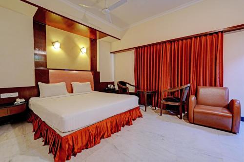 a hotel room with a bed and a chair at Palette - Chennai Deluxe Koyambedu in Chennai