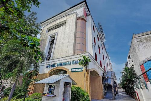 un edificio con una casa de perros delante de él en Palette - Chennai Deluxe Koyambedu en Chennai