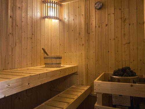 a sauna with wooden walls and a clock on the wall at Haus Anastasia in Stolberg i. Harz