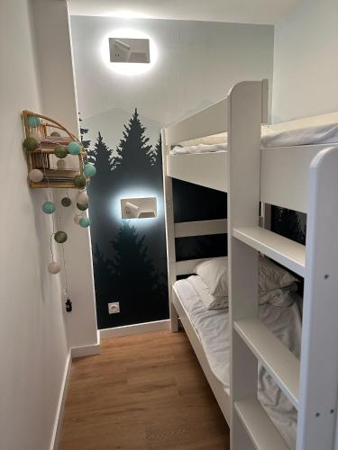 Cette chambre dispose de lits superposés et d'une fresque murale représentant la forêt. dans l'établissement Sacaron24, T2 bis, centre Luchon, wifi, parking, à Luchon