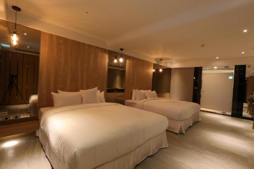 a hotel room with two beds in a room at 薇風情汽車旅館 - 鳳山館 in Kaohsiung