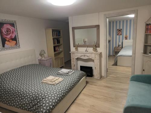 1 dormitorio con 1 cama con chimenea y espejo en Alessandra‘s House, en Arezzo