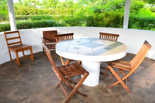 een tafel en 4 stoelen op een patio bij Garden house 2 in Ukunda