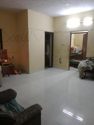 an empty living room with a large white tile floor at Kalyani Dwarka Illam in Chennai
