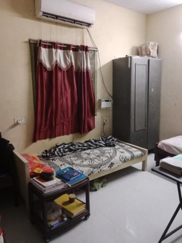 Habitación pequeña con cama y ventana en Kalyani Dwarka Illam en Chennai
