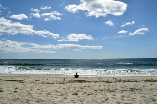 a person sitting on the beach looking at the ocean at Dommu Livia in Lotzorai