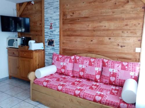 un salon avec un canapé rouge et une cuisine dans l'établissement Studio cosy 4 pers, RDC, Sud, à 300m des pistes et 250m commerces, bien équipé, animaux admis. - FR-1-733-116, à Crest-Voland