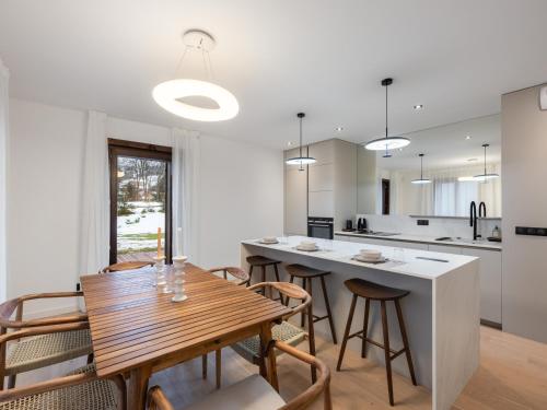 une cuisine et une salle à manger avec une table et des chaises en bois dans l'établissement Appartement moderne 98m² à Megève, proche centre et remontées mécaniques, 6 pers, jardin privatif - FR-1-569-129, à Megève