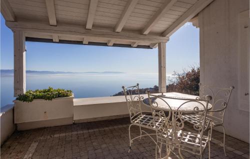 einen Tisch und Stühle auf einem Balkon mit Meerblick in der Unterkunft Lovely Home In Icici With House A Mountain View in Ičići