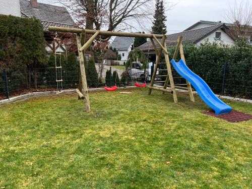 un parque infantil con un tobogán azul en un patio en Ferienhaus Ferati, en Günzburg