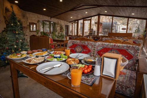 a table with plates of food and a christmas tree at Zeus Cave Suites in Goreme