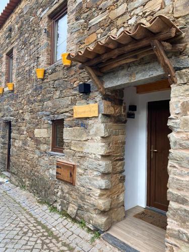 un edificio de piedra con una puerta de madera. en Casa do Tear en Sobreira Formosa