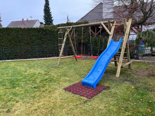 - une aire de jeux avec un toboggan bleu dans la cour dans l'établissement Ferienhaus Ferati, à Guntzbourg