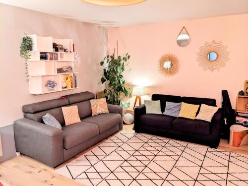 uma sala de estar com um sofá, um sofá e uma mesa em Grand et charmant appartement familial, 3 chambres, et moderne avec grand jardin et parking privatif aux portes de Paris em La Garenne-Colombes