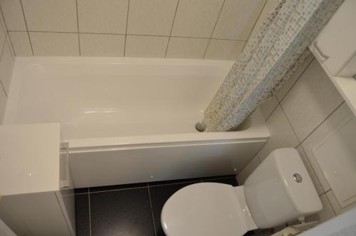 a bathroom with a toilet and a shower curtain at P Apartment in Rēzekne