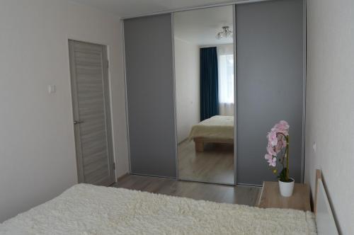 a mirror in a bedroom with a bed and a room at P Apartment in Rēzekne