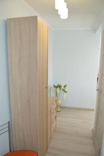 a room with a wooden closet with a dresser in it at P Apartment in Rēzekne