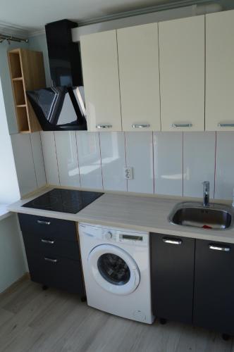 a kitchen with a washing machine and a sink at P Apartment in Rēzekne
