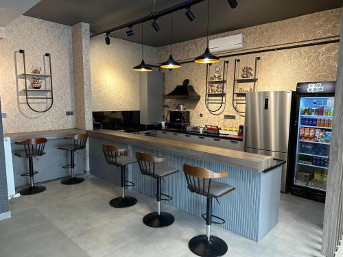a kitchen with a bar with stools and a refrigerator at MARASIUM SUITES in Kahramanmaraş