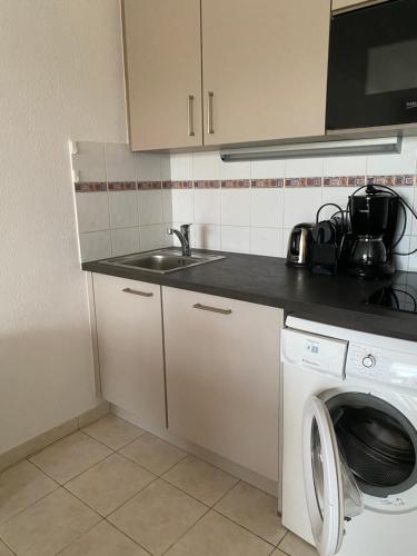 a kitchen with a sink and a washing machine at APPART - T3 - 6 PERSONNES – GOLF CAP D’AGDE in Cap d'Agde