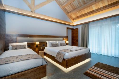 a bedroom with two beds and a large window at Kile Alpine Resort in Valbruna