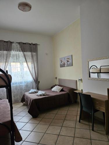 - une chambre avec un lit, une table et un bureau dans l'établissement Dimora Sole del Sud, à Ugento