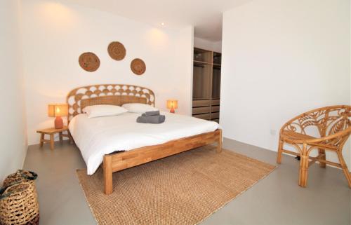 a bedroom with a bed and a chair at La madrague-Villa/Piscine vue Mer/Clim/Wifi in Hyères